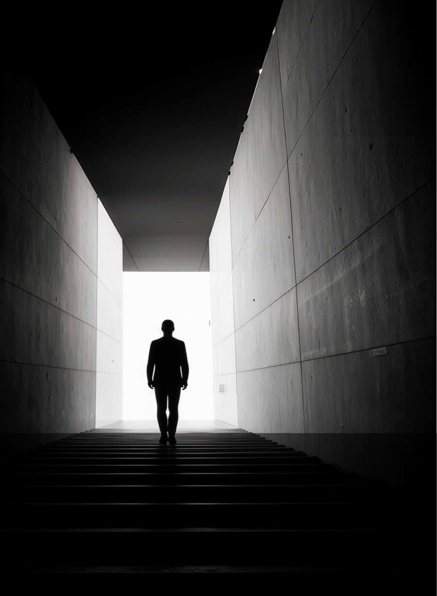 A figure walking up a corridor towards the light